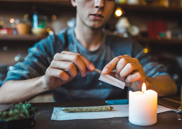 Cropped Shot Of Young Man Making Marijuana Joint